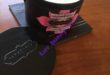 Tropical Plumeria scented massage candle in black tin, by Kama Sutra.
