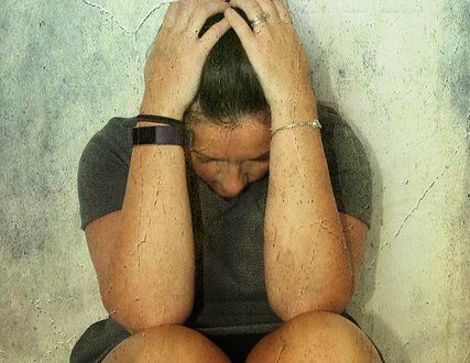 Woman sitting with her head in her hands