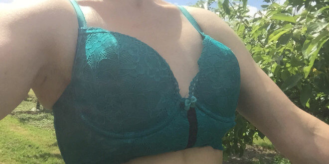 Luv Bunny wearing a teal bra in an apple orchard