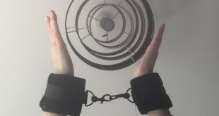 Luv Bunny's wrists linked together in black cuffs