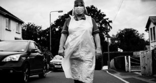 Black and white photo of a care worker in PPE